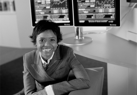 Mellody Hobson sitting in front of computer screens with stock charts
